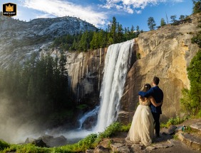 Yosemite National Park, California, is where the couple stand silhouetted against the last light of a dramatic sunset, gazing toward the powerful spray of Vernal Falls.